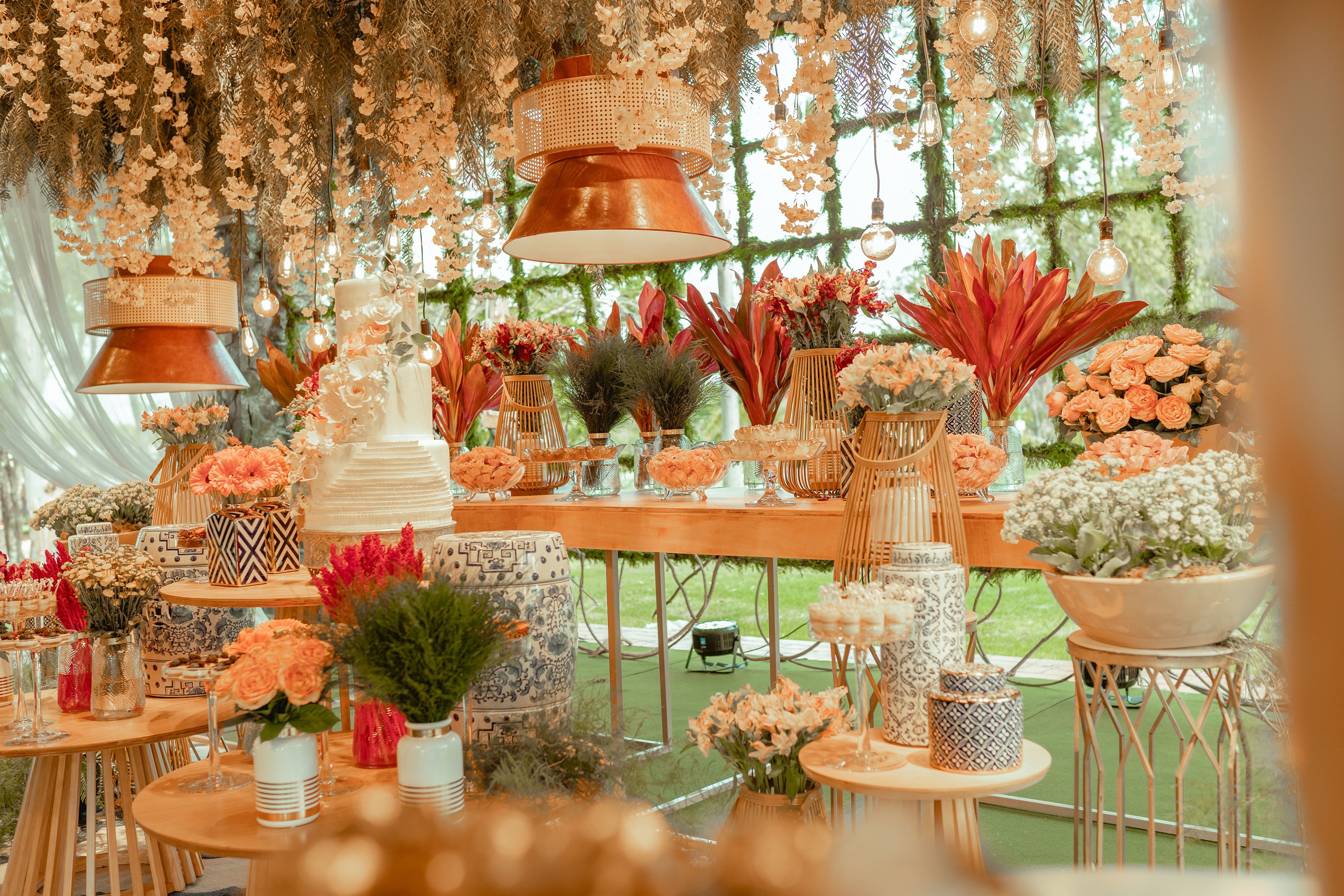 Wedding dessert table styled with flowers and warm-toned decor